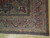 Corner detail of navy main border, olive guard stripes and ivory fringe on hand knotted wool
