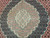 Macro of the scalloped medallion core in ivory, celadon and rose over midnight navy