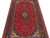 Close perspective across the crimson field with dense floral scrollwork and ivory corner spandrels