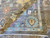 Folded corner revealing the dense hand-knotted back of this 8x10 Oushak wool area rug