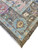 Corner detail showing light blue border, brown outer band and clean ivory cotton fringe