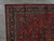 Corner detail on grey tile showing indigo main border, ivory guard stripes and ivory fringe