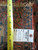 Tape measure and hand-woven oriental rug tag marked size 4.7 x 5.10 beside knotted fringe