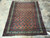 4'7" x 5'10" Persian Mahal rug lying on travertine tile floor showing full boteh design