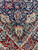 Close-up of navy blue field meeting ivory spandrel with green vine work and palmettes
