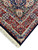 Corner detail with ivory fringe, light blue guard border and burgundy main border rosettes