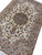 Diagonal view of the hand-knotted medallion rug with dense floral vinework across the cream field