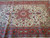7x10 Persian Tabriz rug border detail in coral red with navy guard stripes and rosettes