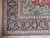 Corner detail of dark indigo palmette border, ivory guard stripe and clean hand-tied fringe