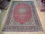 9'5" x 13'7" Persian Najafabad rug displayed flat on light wood showroom floor