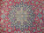 Close-up of navy star medallion with ivory rosette center and hand-knotted wool pile detail