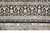 End border bands of navy and aqua florals framing the woven signature and pale fringe