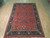 7'3" x 11' Persian Sarough rug displayed on light hardwood floor showing full floral layout