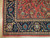 Corner detail showing navy border with 8 petal rosettes and vine scroll, Sarouk design