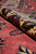 Rolled edge showing pile depth, cream border wool and the coral red field beside it