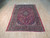 Angled floor view of semi-antique Kashan rug, deep red field, teal accents, dense wool pile