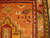 Close-up of woven inscription, rosette and bird motif beside the salmon and gold Kazak border