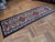 3'3" x 10'3" Persian runner displayed diagonally across herringbone parquet in a hallway setting