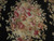 Close-up of crimson roses, peach fruit and pineapple motif woven in finely shaded wool