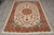 5'4" x 7'8" wool and silk Tabriz rug shown full length on grey tile floor