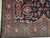 Corner detail showing rust main border with 8 petal star rosettes and guard stripes
