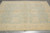5'9 x 8'1 hand-knotted Ziegler rug photographed from one end on grey tile flooring