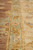 Macro detail of sage green guard stripe dividing the ivory border from the rust colored field