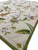 Perspective view of 6x9 ivory monkey rug corner with green border and flowering vine