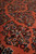 Angled macro of the wool pile showing detached floral sprays in navy, ivory and brown