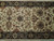 Close-up of all over floral field showing gold palmettes, rust rosettes and sage green vine scrolls