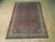 Full 7x10 Persian Bijar rug photographed flat on light wood floor showing complete design