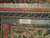 Ruler and Authentic Handmade tag against the cotton fringe and borders of this Persian rug