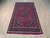 Angled view of the 6x10 semi-antique Mashad rug, navy border and cream guard stripes
