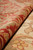 6x6 Oushak wool rug rolled back to show pile depth, coral border and beige field
