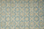 Close-up of ivory floral lattice and 8 petal rosettes on light blue field