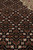 Dense herati lattice in black and rust photographed close to show fine knots per square inch