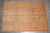 10'2" x 13'8" Agra wool rug photographed flat on grey tile showing soft camel field