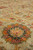 Close-up of field palmette in orange, coral and green on hand-knotted wool pile