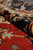 10 by 14 foot Serapi rug rolled to show thick wool pile depth and border