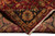 Folded corner showing plush pile depth, black border palmette and ivory cotton fringe ends