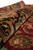 Rolled edge detail displaying lustrous wool sheen across black border paisley and red field