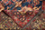 Folded corner revealing dense silky wool pile, red guard border and hand-tied grey fringe