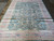Vintage blue Persian rug photographed lengthwise showing pink border, ivory corner panels and floral field