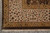 Corner detail of ivory border, gold leaf stripe and dark brown selvage with fringe