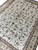 Diagonal view of the hand-knotted Chinese rug, all over floral field framed by champagne border