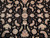 Close-up of rose and ivory palmettes, lotus blossoms and scrolling vines on black wool pile