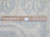 Back of the rug beside a ruler, showing even hand-knotted rows and authentic handmade tag