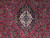 Close-up of ivory and light blue medallion centered on the dark pink wool field