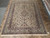 9'9" x 12'10" ivory Persian rug laid flat showing even wool pile and straight edges