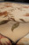 Corner view showing carved silk leaf outlines and dense wool pile on contemporary beige floral rug